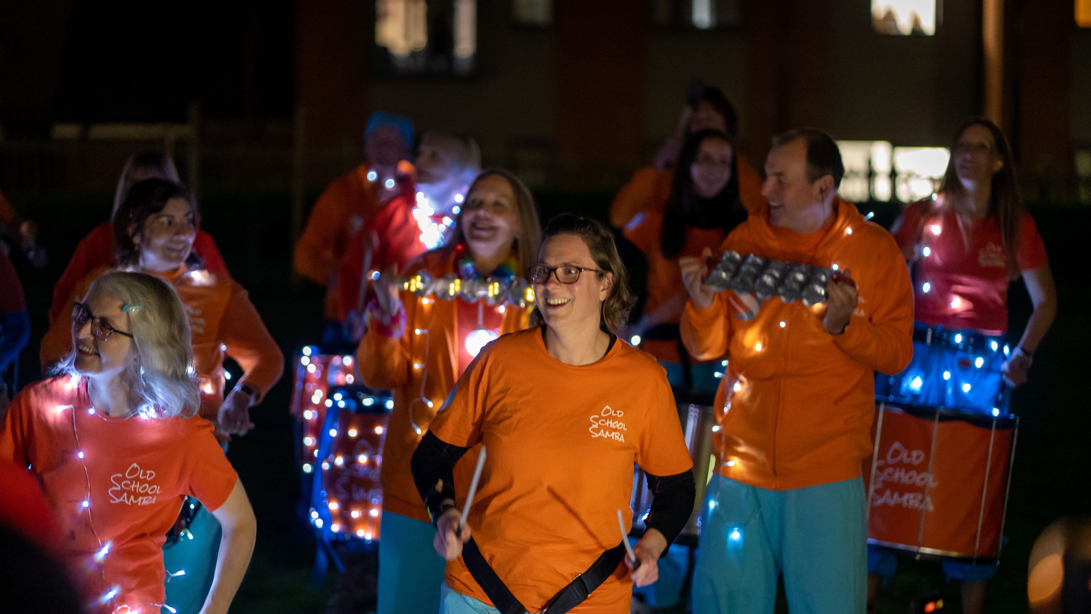 Image of Old School Samba Band playing instruments with fairy lighting