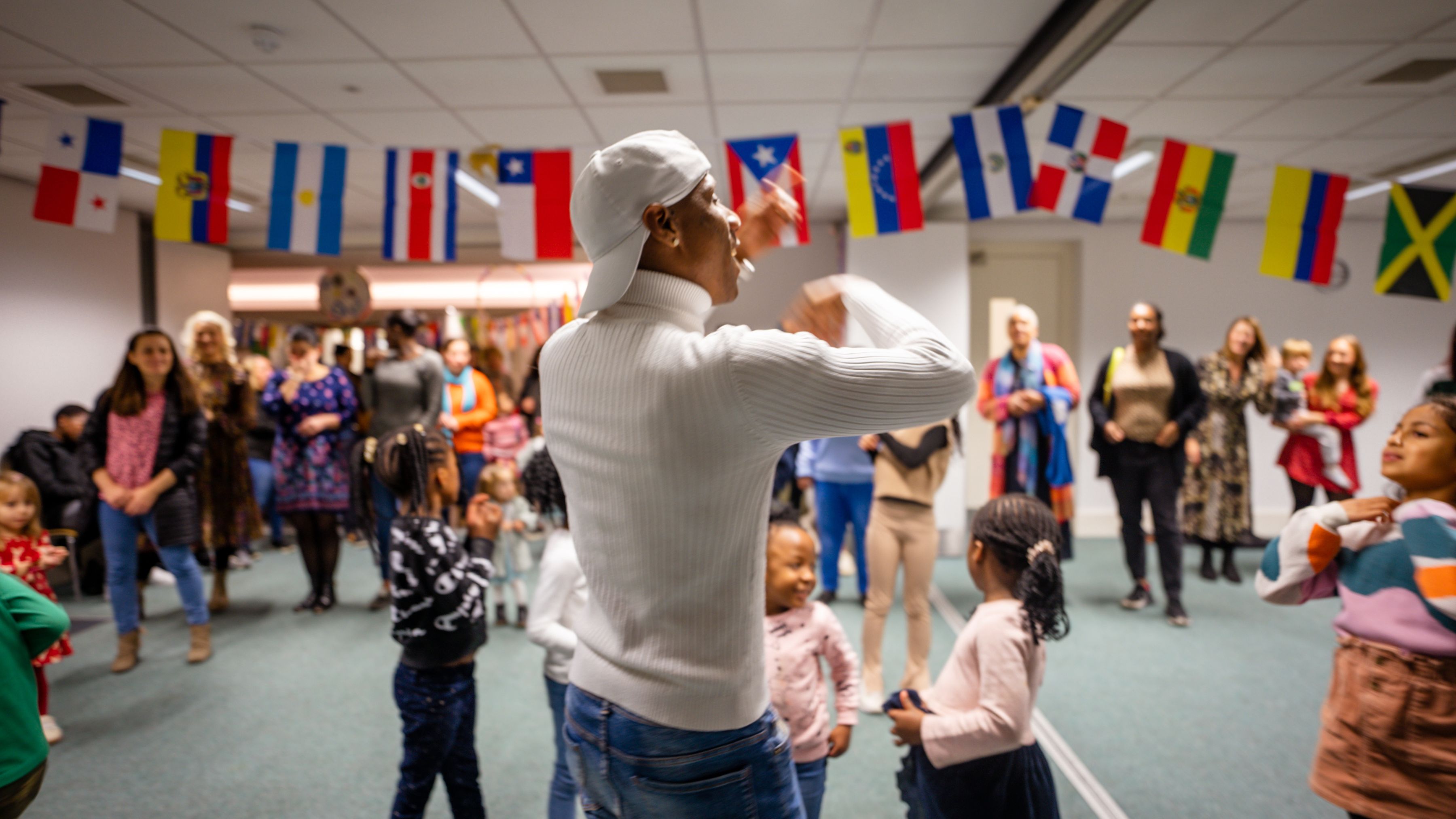 Image of male dancing instructor teaching salsa with flags in the background