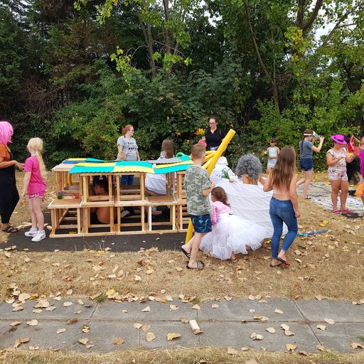 Image of children playing in a playground with fancy dress and wooden play structures.